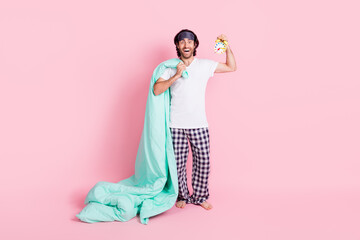 Full size photo of happy excited crazy man in pajamas hold clock and blanket good morning isolate on pink color background
