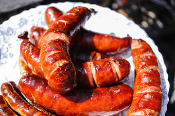 Fried sausages on a fire in a plate in a close-up