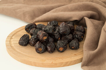 Dried Acve date fruit or Hurma in the copper plate on the black background for Ramadan tables concept.