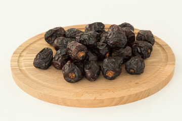 Dried Acve date fruit or Hurma in the copper plate on the black background for Ramadan tables concept.