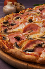 pizza with ham and mushrooms on a wooden Board. close up