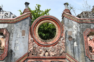 Hoi An, Vietnam, May 6, 2021: Central circle-shaped sculpture of the Ba Mu Temple gate in Hoi An