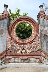 Hoi An, Vietnam, May 6, 2021: Vertical view of the central circle-shaped sculpture of the Ba Mu Temple gate in Hoi An