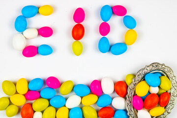 Eid text written with candies on white background