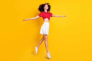 Fototapeta na wymiar Full length photo of charming lady look go empty space raise hands isolated on yellow color background