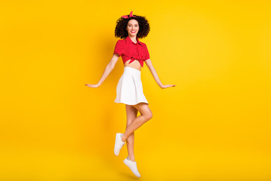 Full size profile photo of cool optimistic brunette hair lady jump wear red top band skirt isolated on yellow color background