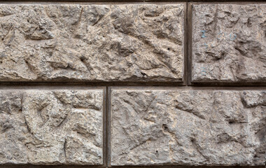 Textured brick wall of gray color, stone background, in close-up