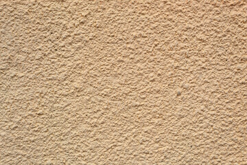 Textured background, yellow wall with stone in close-up