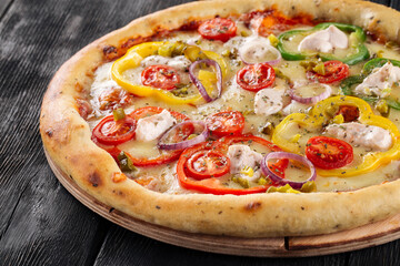 Pizza with bell pepper and mozzarella on the dark wooden background