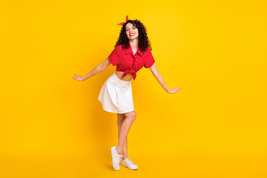 Full size photo of cute optimistic brunette hair lady dance wear red top skirt sneakers isolated on yellow color background