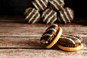 Chocolate macaroni, on a wood background, in the dark, in close-up, still life, cookies