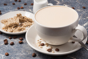 Obraz na płótnie Canvas coffee with milk and halva on a gray background