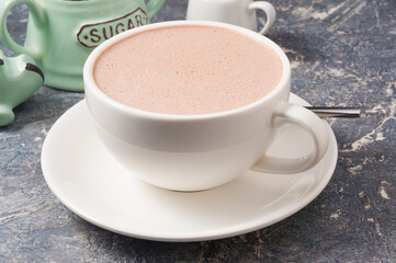 white Cup of cocoa with milk on a grey background