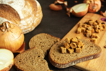 Homemade croutons with bread with onions, croutons on bread on a dark background, still life