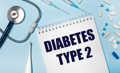 On a light gray background, a stethoscope, an electronic thermometer, pills, syringes and a notebook with the text DIABETES TYPE 2. Medical concept.