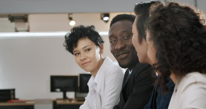 Business team talking, smiling through window.
