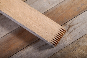 Finger joint at the end of wood sticks. Woodworking background.