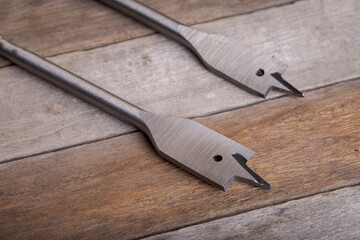 Feather wood drill bit on wooden background. Drill bit for wood on natural wood background....