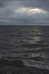 Coast with a beautiful dramatic evening sky. Water waves.