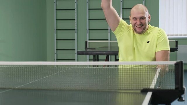A man in a wheelchair plays ping pong. People with disabilities play table tennis. Rehabilitation of the disabled. Paralympic sport.