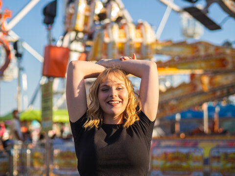 Mujer joven disfrutando de las vacaciones de verano en un parque de atracciones 