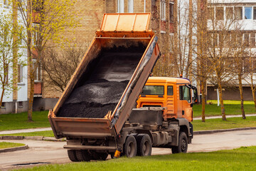 Tipper unloading fresh asphalt from body © graja