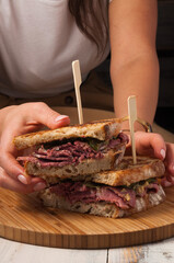 a beef sandwich in the girl's hand. The vertical frame. Close up