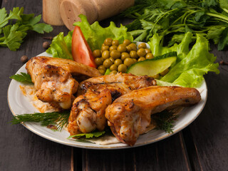 tasty grilled chicken wings decorated with vegetables
