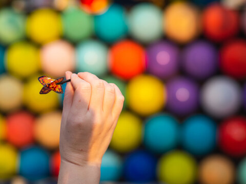 Mano sujetando un dardo en una t&oacute;mbola de globos 
