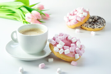 Donut sprinkled with marshmallows with cappuccino on a white background, flowers background, isolated