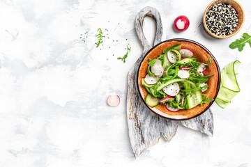 Salad with fresh vegetables of radish, cucumbers and arugula. Healthy vegetarian food. banner, menu...