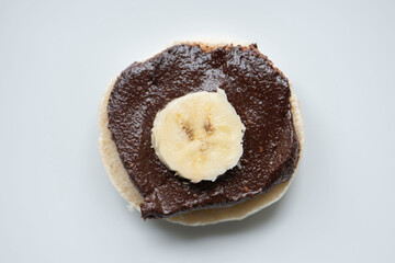 glutenfreie Semmel, selbstgemachte Haselnuss Creme mit Ahornsirup und einer Scheibe Banane
