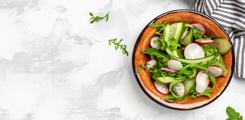 Healthy food nourishment diet detox dieting fresh vegetable salad of radish, cucumbers, arugula, vegan vegetarian food concept. Long banner format, top view
