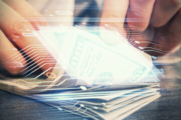 Double exposure of technology drawing hologram and us dollars bills and man hands. Data concept