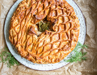 Puff pastry pie with chicken and leek decorated with dill. Top view. © valentinamaslova