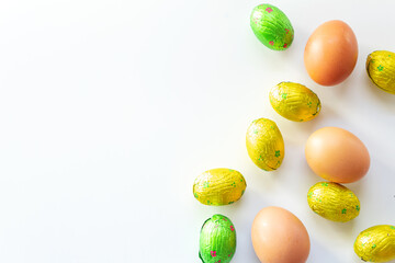 Chicken eggs mixed with chocolate scattered on white background, isolated, top view
