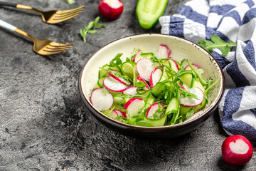 Vegetable salad of fresh cucumbers, radish and arugula. Diet detox food concept. banner, menu recipe place for text, top view