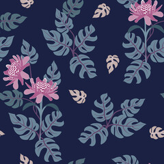 Seamless vector illustration with beautiful tropical flowers and leaves on a dark blue background.