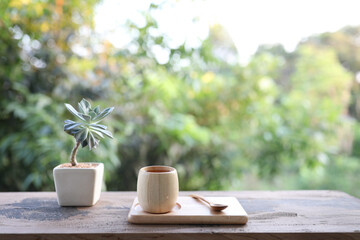 Wooden bamboo cup and plate and wooden spoon with plant pot on table