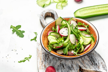Vegetable salad with radish, cucumbers and arugula. Concept for a tasty and healthy meal. Food recipe background. place for text, top view