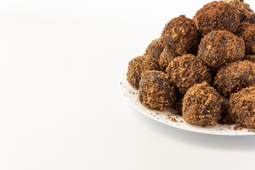 Chocolate balls sprinkled with cocoa powder, in a plate