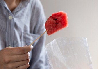 People eating watermelon slices in plastic bag with Blurred background