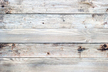 Texture of the planks of an old wooden table in antiqued light pastel colors. Vintage rustic wooden background. Carpentry.