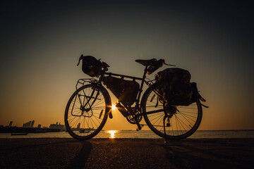 Fototapeta na wymiar Touring bikes parked by the sea at Ban Na Kluea Bay during sunset in Pattaya, Naklua, Thailand.