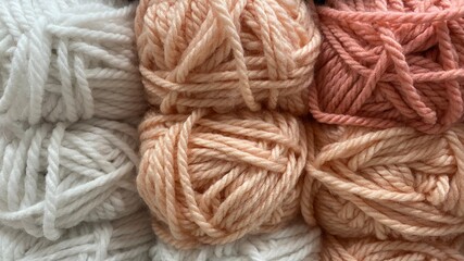 beige, pink and white range of wool yarn. Multicolored skeins of wool close-up