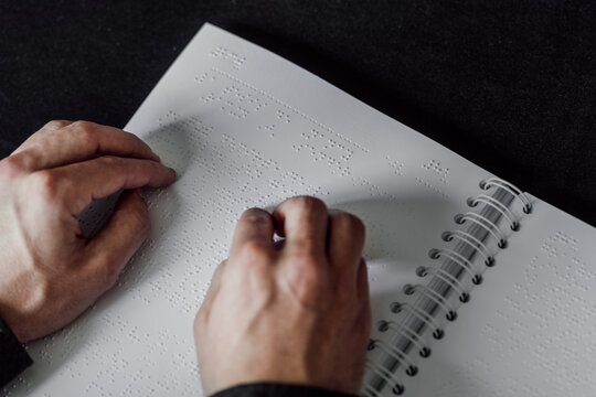 Man reading Braille book