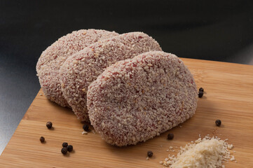 raw cutlets in breadcrumbs on a wooden Board