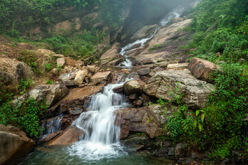 Naklejka na ściany i meble Small waterfall in forest. Lao Cai province, Vietnam.