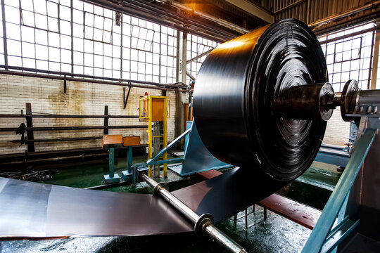 Close up of a roll of rubber on a machine in a conveyor belt factory