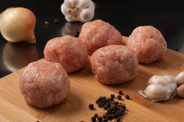 raw meatballs chicken or pig on wooden Board